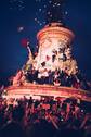 Un feu d’artifice, un vrai, avec ses pluies de lumières dorées et son bruit de tonnerre, qui surplombe pendant quelques secondes la place de la République, noire de monde. Sur la statue bondée, on continue de se faire la courte échelle pour grimper, toujours plus haut, toujours plus serrés. Dans la foule compacte on chante, contre Macron, contre les fachos, contre le Rassemblement national, contre Bardella, contre Bolloré, contre Hannouna.