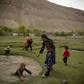 Keshroo et sa famille dans le district de Yamit dans le Badakhshan, le 10 mai. La fille de Kheshroo et son cousin, tous deux élèves de première qui avaient été déscolarisés de force, se sont suicidés un an auparavant. La famille joue dans des flaques d'eau, au milieu de troupes de yacks, de chevaux et de chèvres, devant les montagnes du Wakhan, une région qui n'avait jamais été contrôlée par les talibans avant 2021.